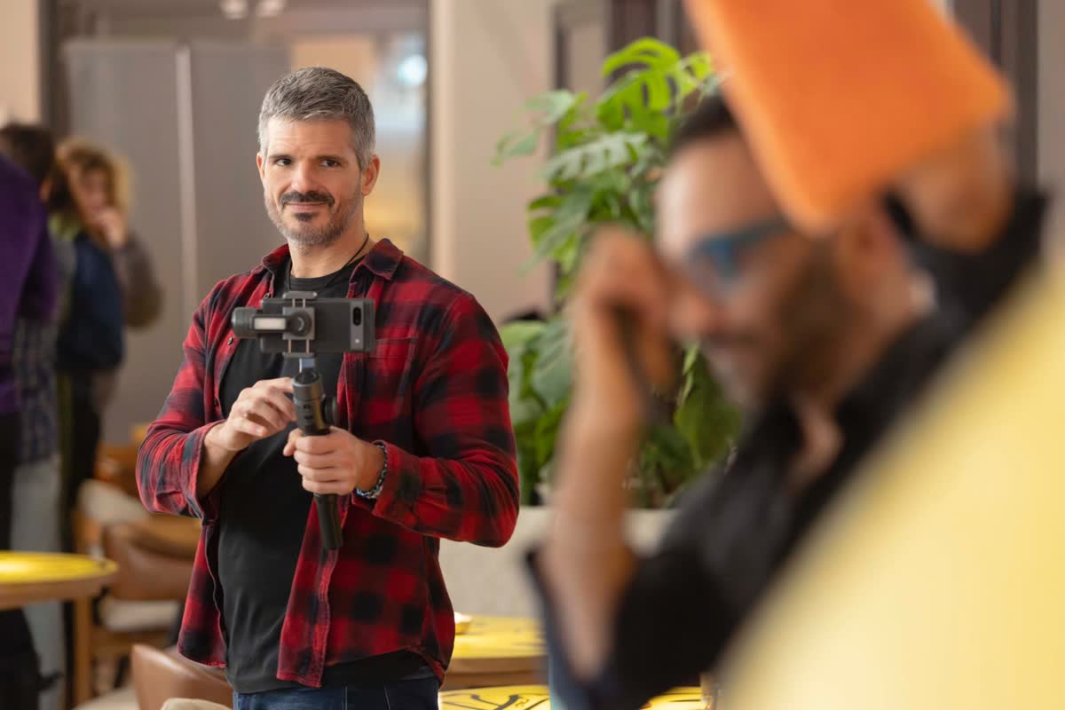 Eduardo filming with a phone gimbal at an indoor event